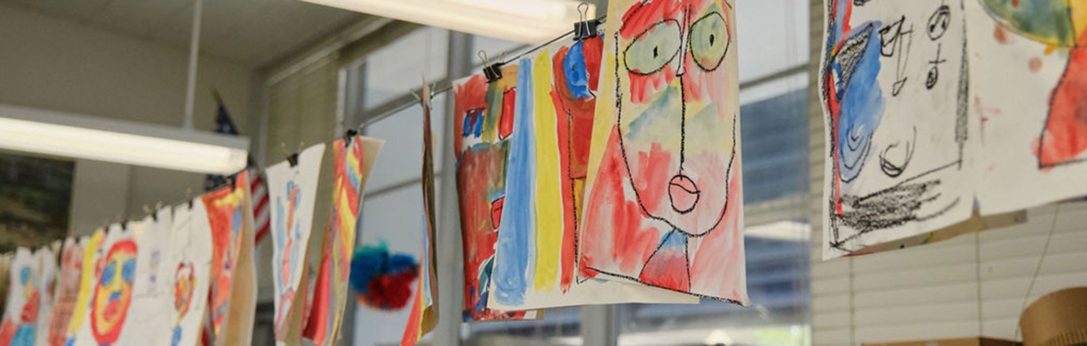 image of vibrantly colored student artwork hanging on a line