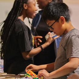 Image of a young asian boy sorting thorugh art supplies